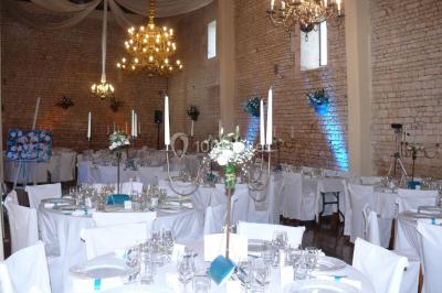 Miniature Grande Nef : tables et chaises fournies Un couple marche dans le jardin d'un château ancien entouré de verdure par une journée ensoleillée.
