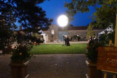 Miniature Romantique Un couple marche dans le jardin d'un château ancien entouré de verdure par une journée ensoleillée.