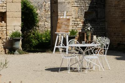 Miniature salon de jardin Un couple marche dans le jardin d'un château ancien entouré de verdure par une journée ensoleillée.