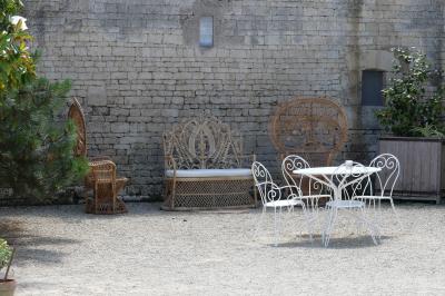 Miniature salon en extérieur Un couple marche dans le jardin d'un château ancien entouré de verdure par une journée ensoleillée.