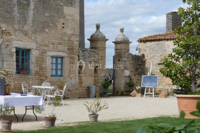 Miniature tables et chaises en fer forgées Un couple marche dans le jardin d'un château ancien entouré de verdure par une journée ensoleillée.