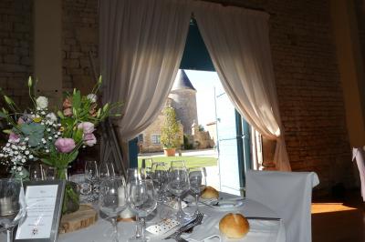 Miniature Vue sur la cour du Pavillon Un couple marche dans le jardin d'un château ancien entouré de verdure par une journée ensoleillée.