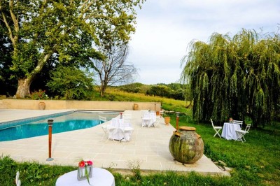 Miniature Location salle Ansouis (Vaucluse) - Le Grand Turcan #6 Salle avec un ancien pressoir en bois, des tonneaux, une table rouge avec bouteilles et des verres à vin.