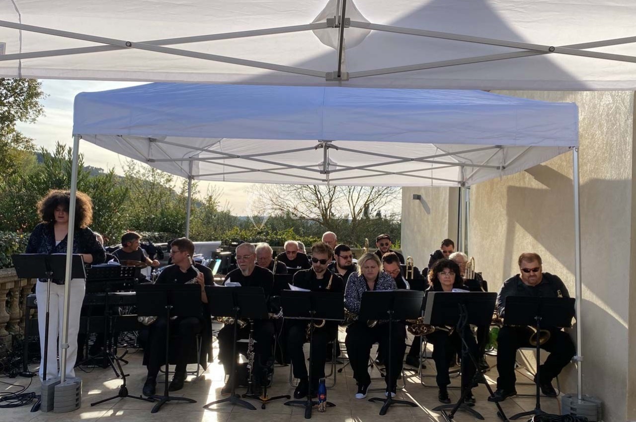 Location salle Ansouis (Vaucluse) - Le Grand Turcan #13 Un groupe de musiciens joue sous une tente blanche en extérieur, avec des pupitres et divers instruments.