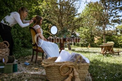 Un couple en tenue de mariage se regarde sous une pergola illuminée de guirlandes lumineuses.