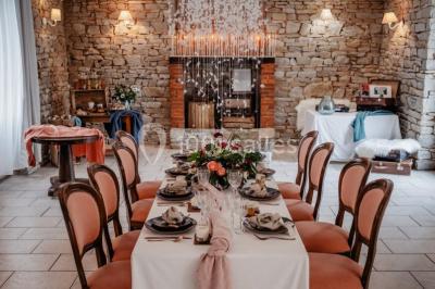 Un couple en tenue de mariage se regarde sous une pergola illuminée de guirlandes lumineuses.