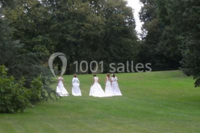 Chambre lumineuse avec un lit double, des rideaux fleuris, un lustre, des meubles classiques et des fenêtres donnant sur la…