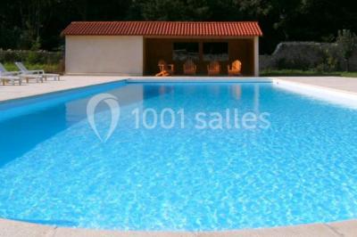 Chambre lumineuse avec un lit double, des rideaux fleuris, un lustre, des meubles classiques et des fenêtres donnant sur la…